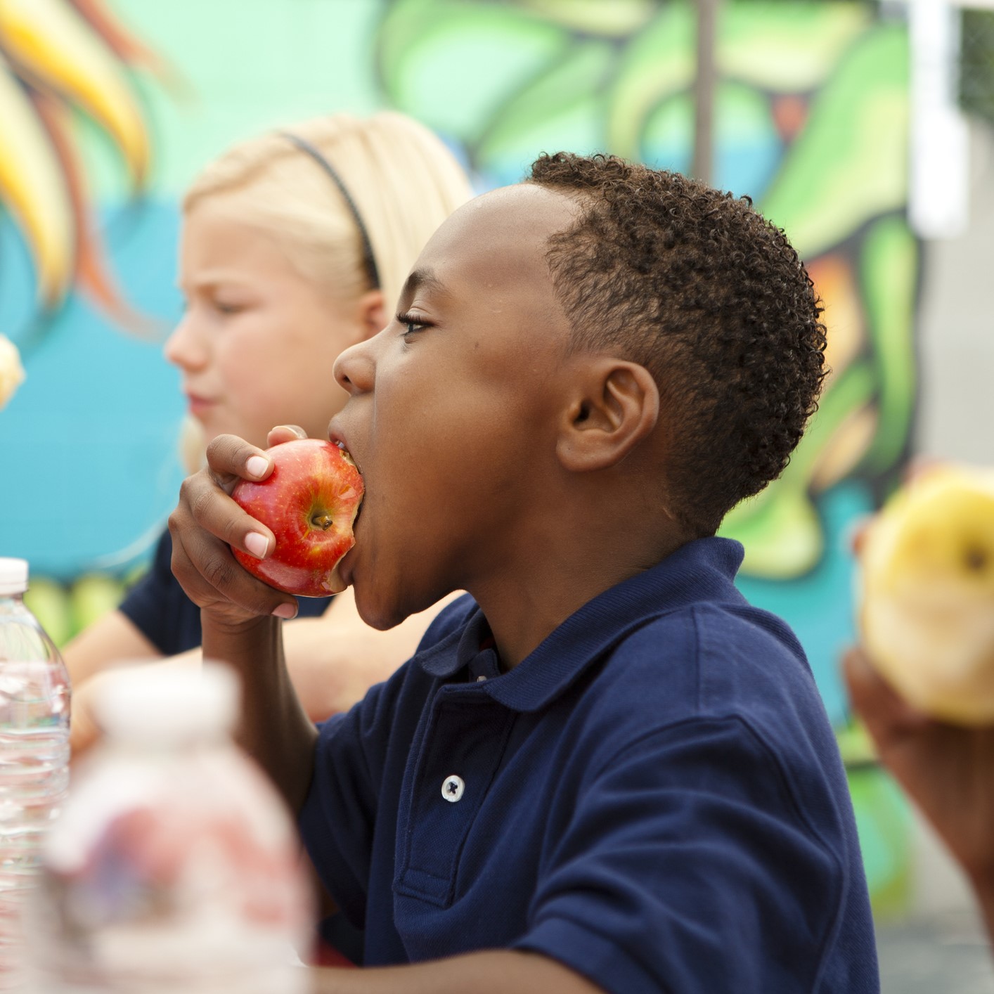 Boy eating an apple at lunch